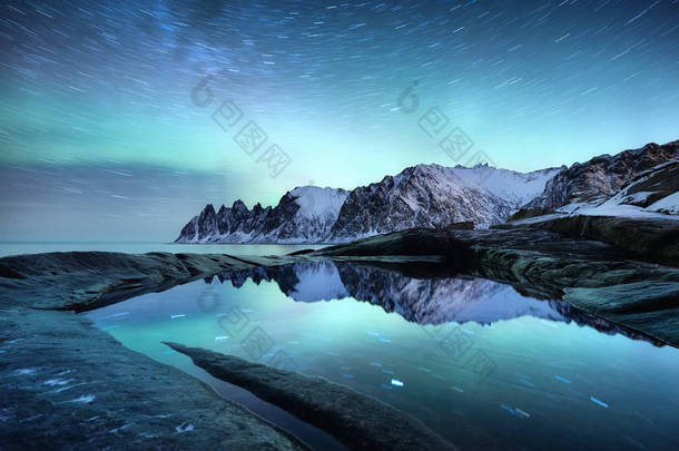 Tungeneset岩石和Aurora Borealis光。星星小径和<strong>北极光</strong>。水面上的反光。挪威塞尼亚岛。旅行-形象