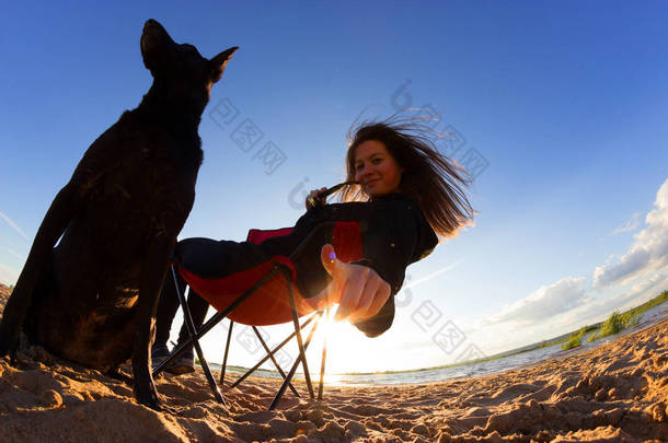 海滩上有狗的沙滩椅女孩