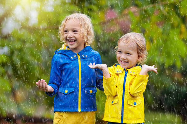 孩子们在秋雨中玩耍。雨天的孩子.