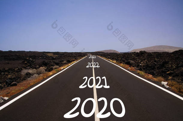 漫长而坚硬的石质成功的道路理念：以2020年、 2021年、 2022年、 2023年的数量在无边无际的柏油路上穿越干旱的火山景观