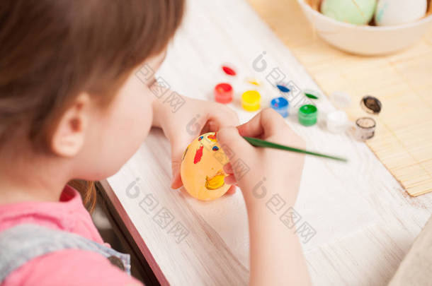 女孩在家里的餐桌上画鸡蛋。