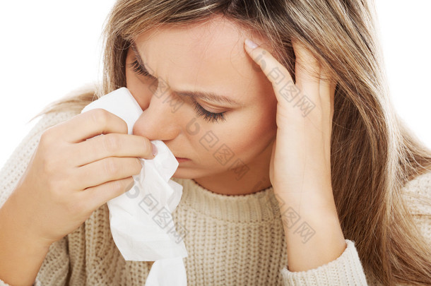 年轻女子用纸巾哭或有流鼻涕的鼻子.