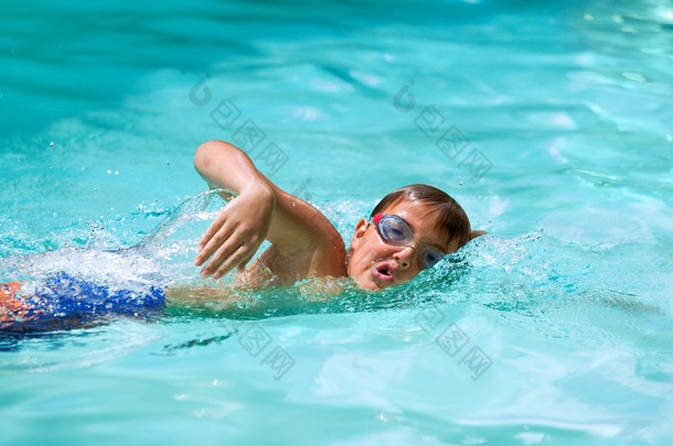 男孩在游泳池练习自由泳.