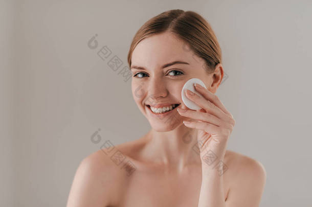 女人用棉垫清洗她的皮肤
