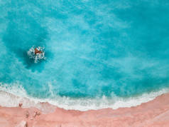 无人机拍摄的美丽的水晶清澈的绿松石和蓝色海水周围的岩石和海浪到达沙滩 