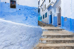一条狭窄的街道，在山与蓝色的建筑，在摩洛哥舍镇的细节