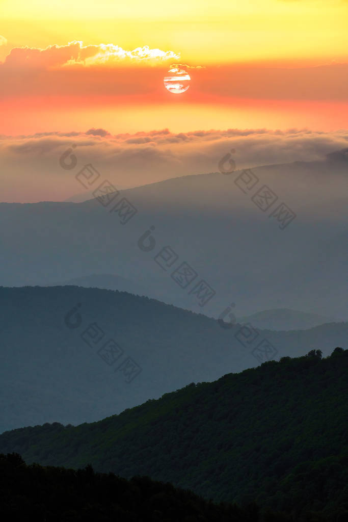 高加索山脉的夏日风景秀丽。太阳设置双心云。美丽的垂直景观.