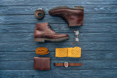 平躺与棕色靴子, 钱包和眼镜在木制背景