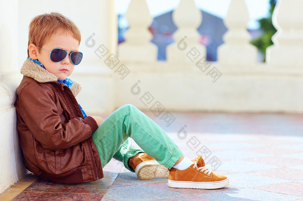 可爱的时尚男孩夹克和胶皮鞋