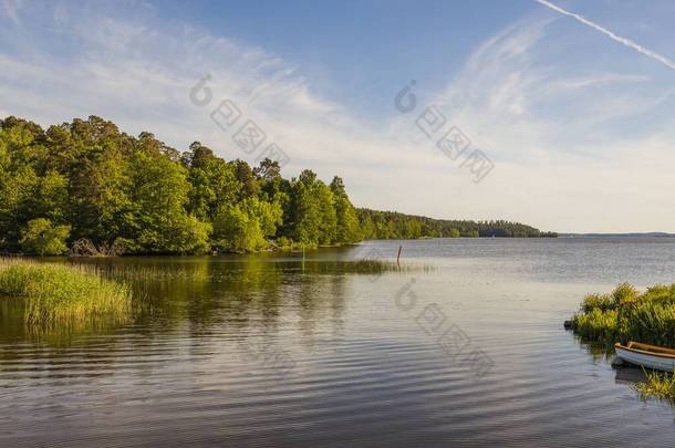 美丽的湖景,蓝天上有<strong>小</strong>船,背景白云.美丽的<strong>夏季</strong>自然背景。瑞典、欧洲.