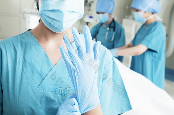 外科医生戴上手套在手术室里