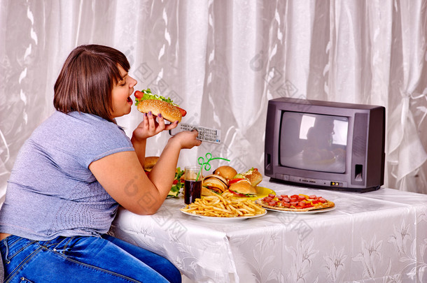 女人吃<strong>快餐</strong>和看电视.