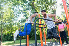 两个强壮的年轻人做垂度锻炼为上部身体室外