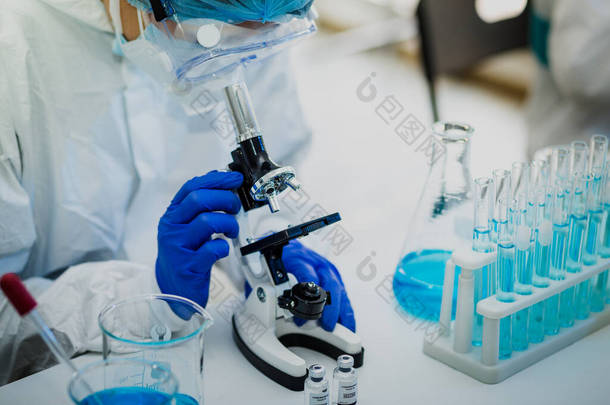 科学家或研究人员手拿蓝色手套，装有流感、麻疹、头孢病毒、眼镜蛇-19型疫苗，为人类临床试验接种疫苗、药物和药物概念做准备.