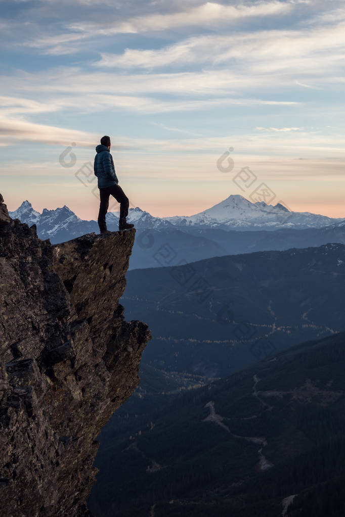 冒险的人站在山顶上, 在充满活力的夕阳中欣赏美景。在加拿大不列颠哥伦比亚省温哥华以东的奇利瓦克 Cheam 山顶上拍摄.