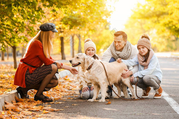 愉快的家庭与狗在秋天公园