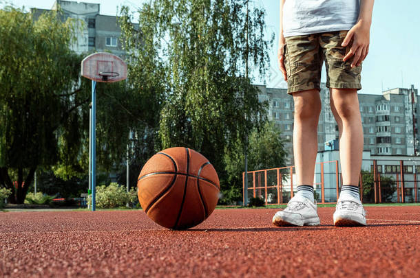 <strong>篮球</strong>场上一个带<strong>篮球</strong>的男孩的肖像。运动生活方式的概念，训练，运动，休闲，度假.