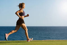 在日落时在海边跑步健身女人