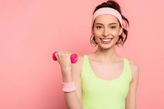 快乐的女运动员，带着粉色哑铃运动 