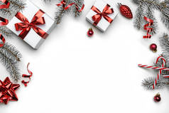 创意框架由圣诞冷杉树枝，礼品盒，红色装饰，闪光和白色背景的意粉制成。圣诞节和新年假期，bokeh，光。平躺在地上，俯瞰四周