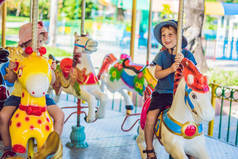 可爱的小男孩和女孩享受在游乐场和骑在五颜六色的传送带房子.