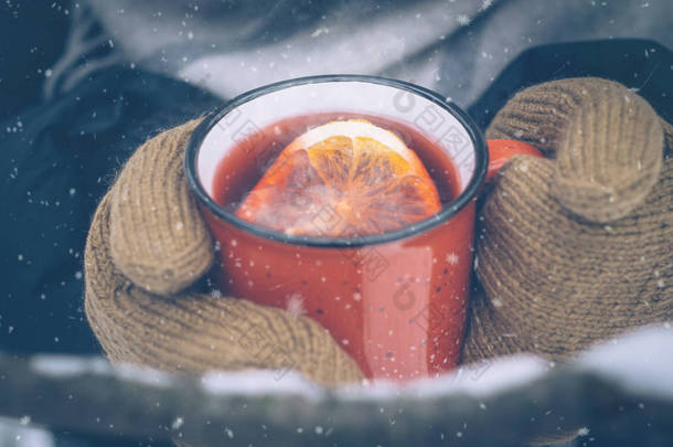 在女人手里的红杯里用磨碎的酒。炎热的<strong>冬季</strong>饮料户外在多雪的<strong>冬季</strong>森林。圣诞节<strong>背景</strong>与雪花