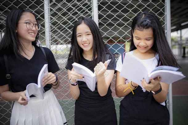 亚洲青少年拿着学校的书, 笑着与幸福 e