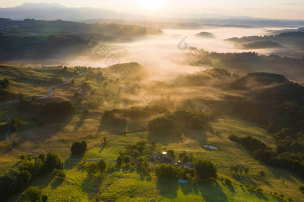 夏日空中俯瞰的川西万山雾蒙蒙的乡村山谷上的神奇日出.