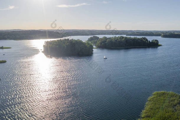 在阳光明媚的夏日，从无人驾驶飞机飞往加尔夫湖的美丽全景航空图。在湖上有许多小船和游艇。在湖心有许多小岛。)