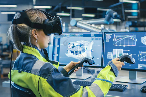 工厂：女工业工程师头戴<strong>虚拟</strong>现实耳机，手持控制器，在CAD软件中使用<strong>VR</strong>技术进行工业设计、开发和原型设计.