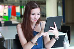 在大学里用平板电脑和微笑刻画泰国人美女的形象.