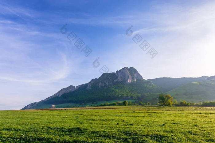 日出时，田里的岩石形成了。 山中美丽的乡村风景。 春天美丽的风景。 蓝天上的云。 山上的森林