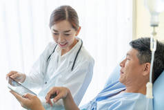 亚洲女医生坐在病床上, 与资深病人选择焦点讨论
