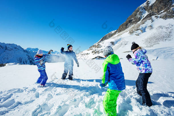四个孩子在山上打雪仗，冬天打雪仗，扔雪球，穿滑雪服