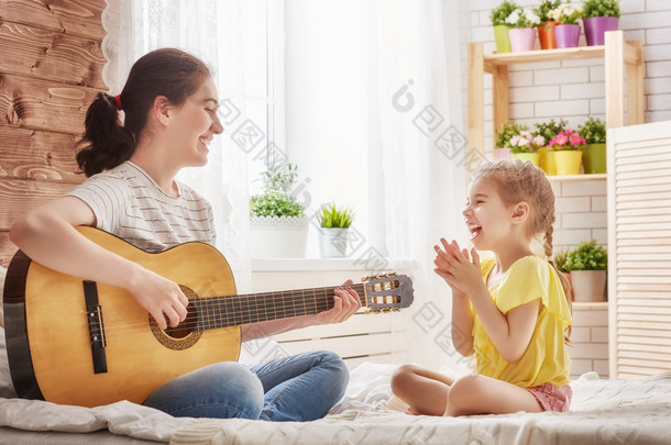 母亲和女儿玩吉他