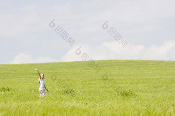 在绿色的原野中年轻快乐的女孩