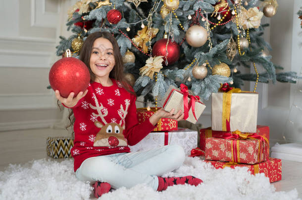 体验圣诞佳节的美景。快乐的孩子拿着光滑的<strong>红球</strong>装饰.圣诞树装饰。节日装饰品和装饰。假日装饰。装饰传统