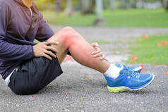 年轻的健身男子抱着他的运动腿受伤, 肌肉在训练中疼痛。亚洲跑步者在夏季外出跑步和锻炼后有小腿疼痛和问题