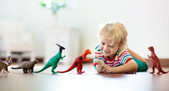 孩子们在玩五颜六色的玩具恐龙.给孩子们的教育玩具小男孩在学习化石和爬行动物。孩子们玩恐龙玩具。幼儿进化与古生物学游戏.