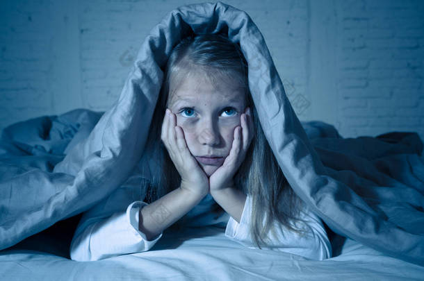 可爱的小白种人女孩躺在床上覆盖着她的头与毯子感到疲惫和不眠不休的痛苦失眠抑郁症压力在儿童情绪和睡眠障碍的概念.