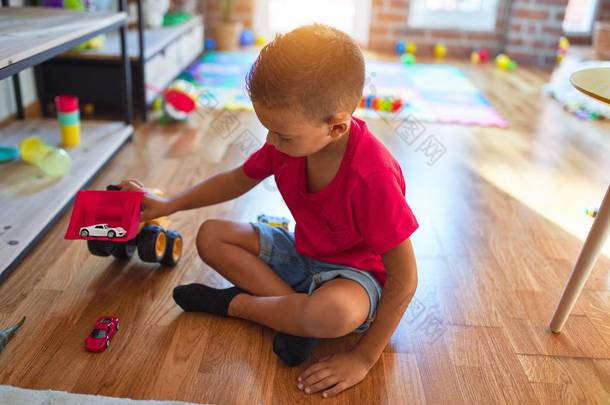 可爱的幼儿在幼稚园里到处玩汽车玩具