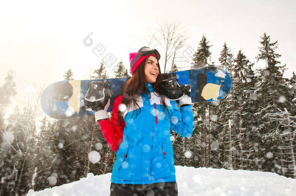 冬季在松树林的降雪中微笑的滑雪女孩