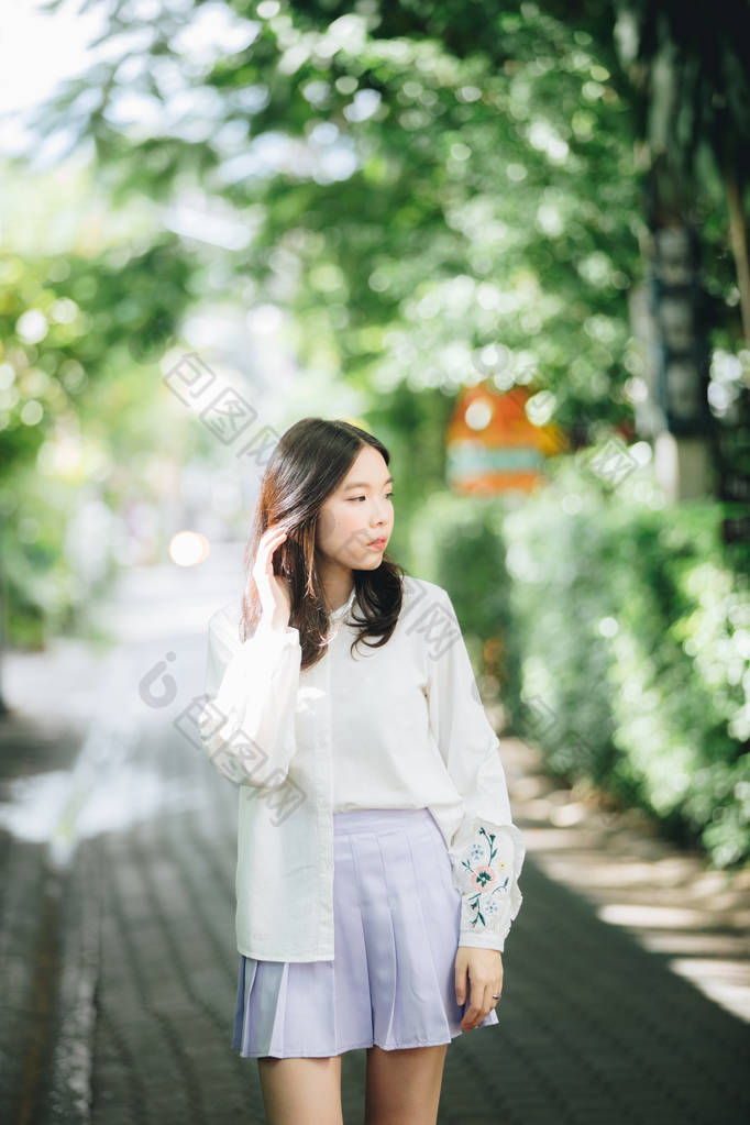 亚洲女孩的肖像，身穿白色衬衫和裙子，外型都市老式电影风格