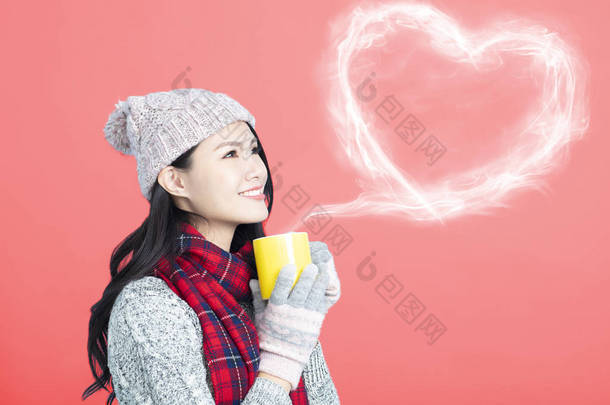 快乐的年轻女子拿着一杯热咖啡或茶
