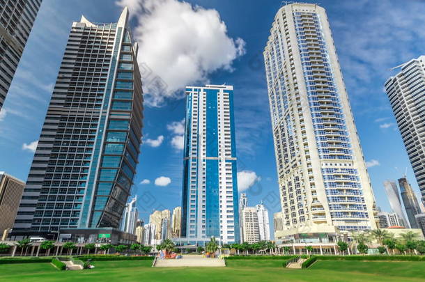 位于阿联酋迪拜的朱美拉湖塔 timelapse 的住宅建筑。猪苓汤是一个大发展包括79个塔与3个人工湖和公园。从公园看蓝色多云的天空