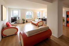 客厅与皮革和实木复合地板设计沙发。大窗户输入大量自然光。里面没人