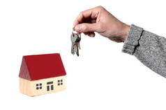 房地产概念：男人的手拿着一把钥匙和一个玩具房子隔离在白色背景与文本的复制空间