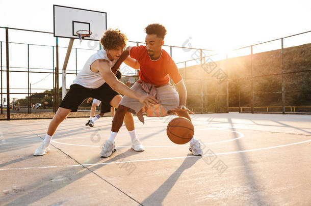 小组年轻运动多民族男子篮球运动员<strong>在</strong>运动场上打篮球