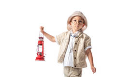 沉思的探险家男孩在眼镜和帽子拿着红灯笼,看着相机隔离在白色