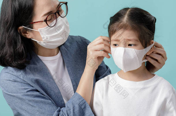 <strong>妈妈</strong>和亚洲小女孩都戴着医用口罩，以保护自己不受污染。中国产的新考拉病毒2019-nCoV，蓝色背景的空旷空间